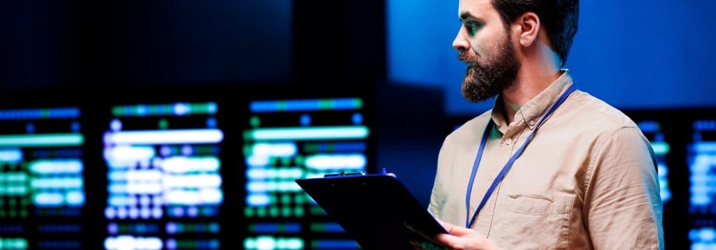 Hombre trabajando en una empresa viendo y comprobando sistemas informáticos.