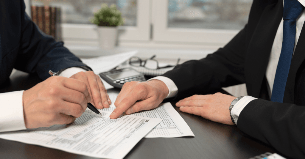 Dos personas revisan documentación relacionada con una notificación tributaria, en el contexto de fiscalidad inmobiliaria.