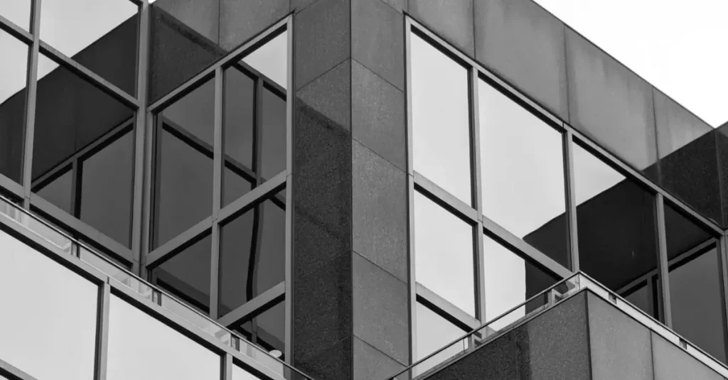 Fachada moderna de un edificio corporativo en blanco y negro, utilizada para representar conceptos vinculados a bonificaciones y gestión empresarial.