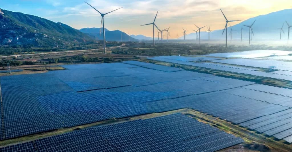 Parque solar con aerogeneradores al fondo; proyectos de energía renovable impulsados por financiación para su desarrollo.