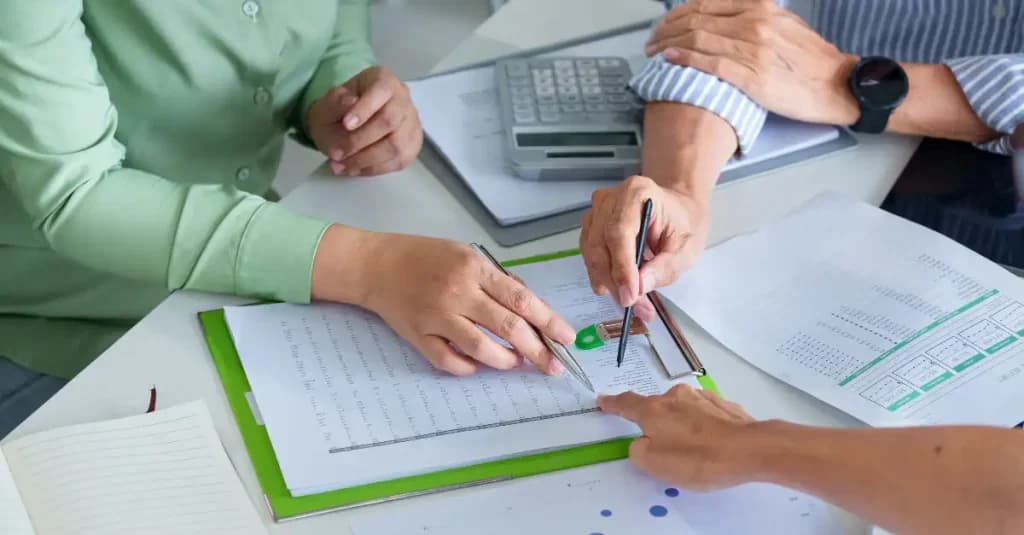 Personas revisando documentos y datos financieros para integrar criterios de sostenibilidad en la planificación empresarial y optimizar la fiscalidad.