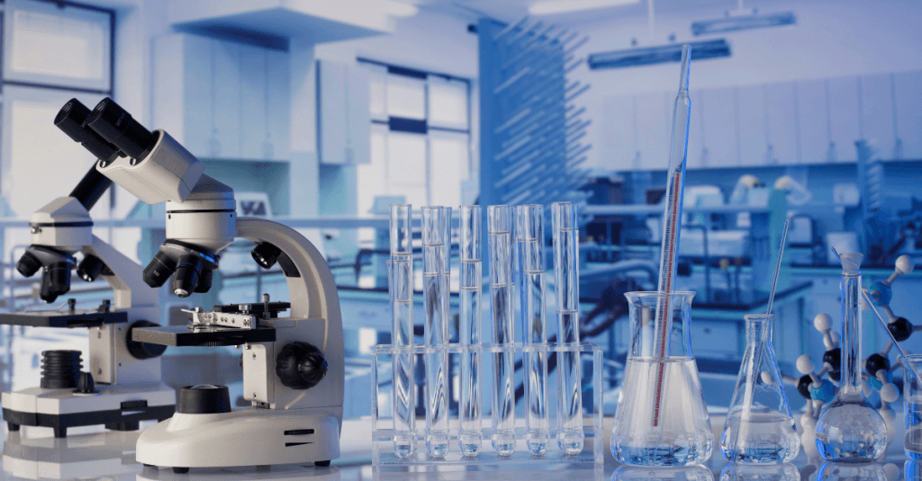 Laboratorio con un microscopio, probetas y tubos de ensayo, en relación con la convocatoria de ayudas Torres Quevedo.