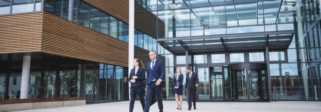 Grupo de personas saliendo de un edificio corporativo, representando el dinamismo empresarial y el compromiso con la innovación, sello PYME innovadora.